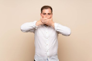Elleriyle ağız kapsayan izole arka plan üzerinde Blonde adam