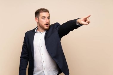 Izole arka plan üzerinde Blonde adam uzağa işaret