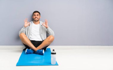 Spor adam parmakları ile ok işareti gösteren bir yerde oturan