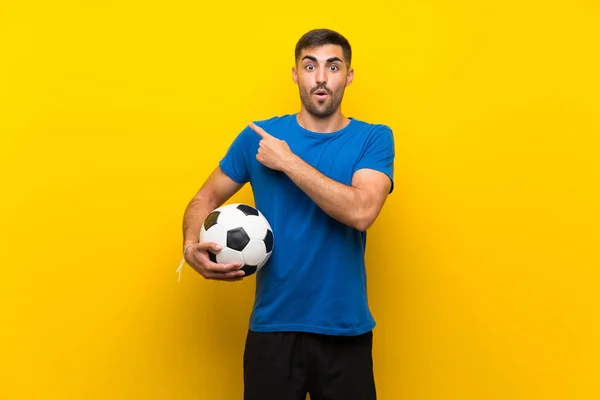 Young Handsome Football Player Man Isolated Yellow Wall Surprised Pointing — Stock Photo, Image