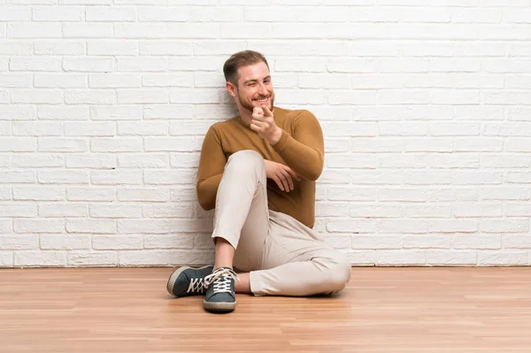 Blonďák Sedící Podlaze Ukazuje Prstem Tebe — Stock fotografie