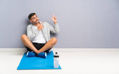 Spor adam işaret parmağı ile işaret eden bir zemin oturan harika bir fikir