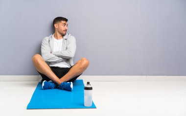 Spor adam bir yerde gülerek oturuyor