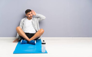 Spor adam bir şey dinlerken bir yerde oturan