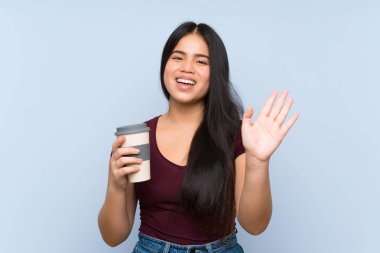 Genç genç Asyalı kız mutlu ifade ile el ile selamlama kahve götürmek tutarak