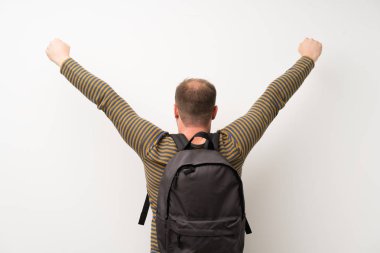 Sırt çantası ile izole beyaz duvar üzerinde yakışıklı adam