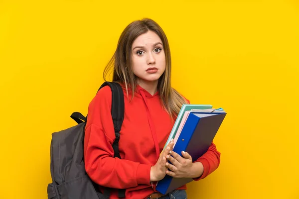 黄色の背景の上のティーンエイジャーの学生の女の子の嘆願 — ストック写真