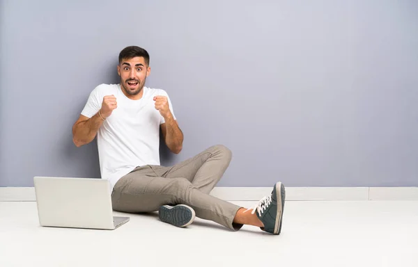 Jovem Com Seu Laptop Sentado Chão Comemorando Uma Vitória — Fotografia de Stock