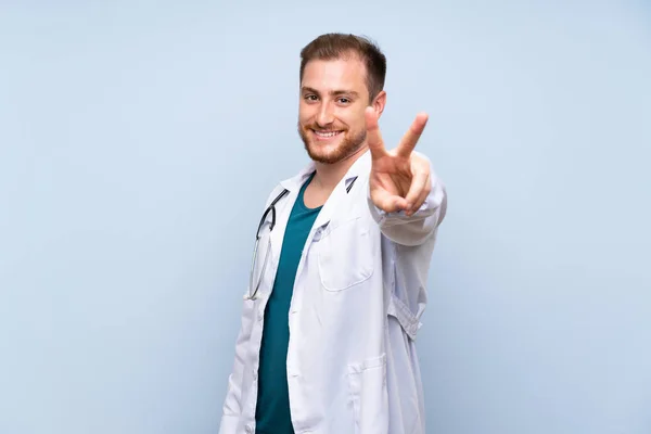 Szép Orvos Ember Több Mint Kék Falat Mosolyogva Mutatja Győzelem — Stock Fotó