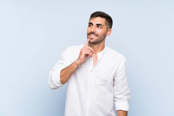 Hombre Guapo Con Barba Sobre Fondo Azul Aislado Pensando Una — Foto de Stock