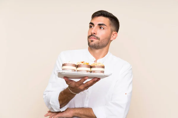 Schöner Mann Mit Muffinkuchen Über Isoliertem Hintergrund Der Lächelnd Nach — Stockfoto