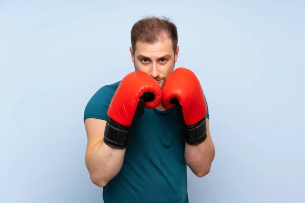 Loira esporte homem sobre azul parede com luvas de boxe — Fotografia de Stock