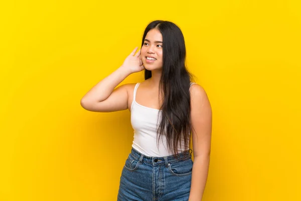 Jonge Tiener Aziatische Meisje Geïsoleerde Gele Achtergrond Luisteren Naar Iets — Stockfoto