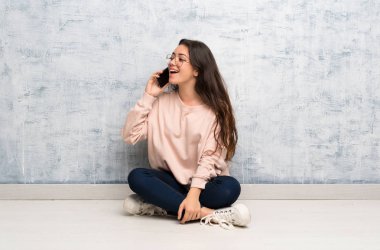 Cep telefonu ile bir konuşma tutmak bir masada okuyan genç öğrenci kız