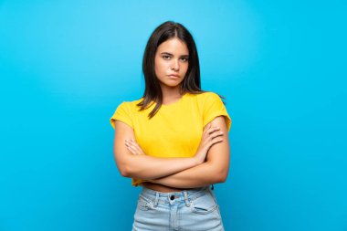 Izole mavi arka plan üzerinde genç kız üzgün duygu