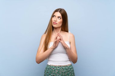 Izole mavi arka plan üzerinde genç kadın bir şey entrika