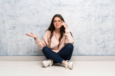 Genç öğrenci kız kafasına parmak koyarak delilik jest yapma bir masada okuyan