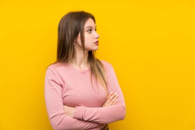 Izole sarı arka plan üzerinde genç kız yan görünümlü