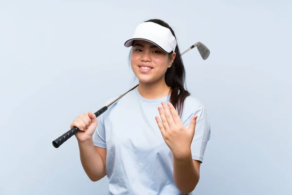 若いゴルファーアジアの女の子は 手で来て招待孤立青の背景の上に 来てくれて嬉しいわ — ストック写真
