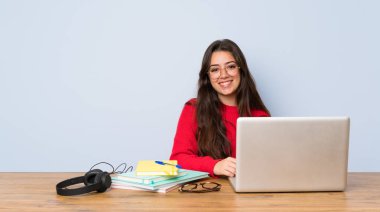 Genç öğrenci kız okuyan bir tablo gülüyor