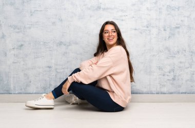 Genç öğrenci kız kolları çapraz ve mutlu bir masada okuyan