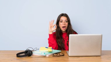 Bir masada okuyan genç öğrenci kız şaşırttı ve ok işareti gösteren