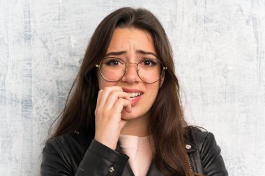 Genç kız grunge duvar üzerinde sinirli ve korkmuş