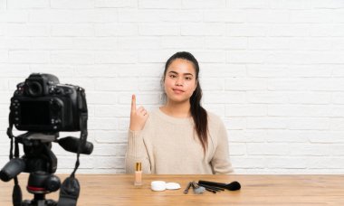Genç blogger Asya kız işaret parmağı ile işaret eden bir video eğitimi kayıt harika bir fikir