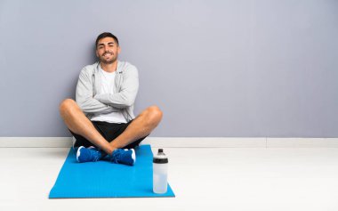 Spor adam bir yerde gülerek oturuyor