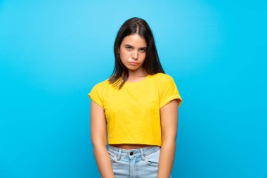 Üzgün ve depresif ifade ile izole mavi arka plan üzerinde Genç kız