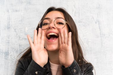 Ağzı tamamen açık bağıran grunge duvar üzerinde genç kız