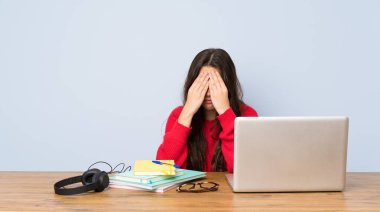 Genç öğrenci kız yorgun ve hasta ifade ile bir masada okuyan