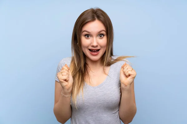 Ragazza Adolescente Oltre Isolato Muro Blu Che Celebra Una Vittoria — Foto Stock