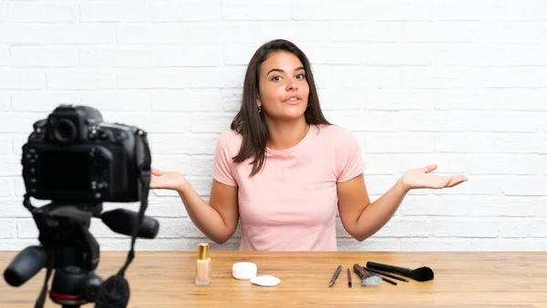 Young girl recording a video tutorial having doubts with confuse face expression