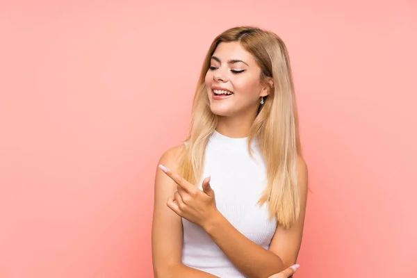 Tonårstjej Över Isolerad Rosa Bakgrund Pekar Finger Sidan — Stockfoto