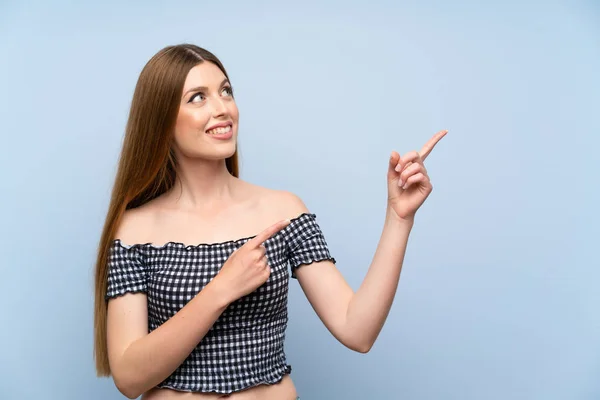 Jonge Vrouw Geïsoleerde Blauwe Achtergrond Wijzen Met Wijsvinger Een Geweldig — Stockfoto