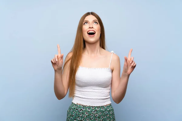 Jovem Mulher Sobre Isolado Fundo Azul Surpreso Apontando Para Cima — Fotografia de Stock