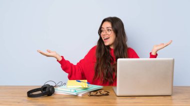 İki eliyle copyspace tutan bir masada okuyan genç öğrenci kız