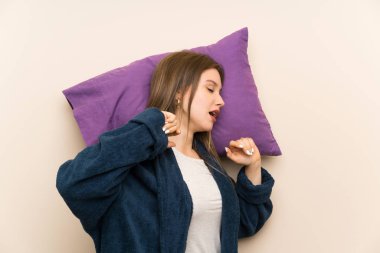Izole arka plan ve esneme üzerinde pijama genç kız