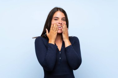 Sürpriz yüz ifadesi ile izole mavi arka plan üzerinde Genç kız