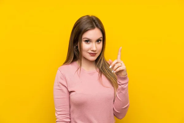 Menina Adolescente Sobre Fundo Amarelo Isolado Apontando Com Dedo Indicador — Fotografia de Stock