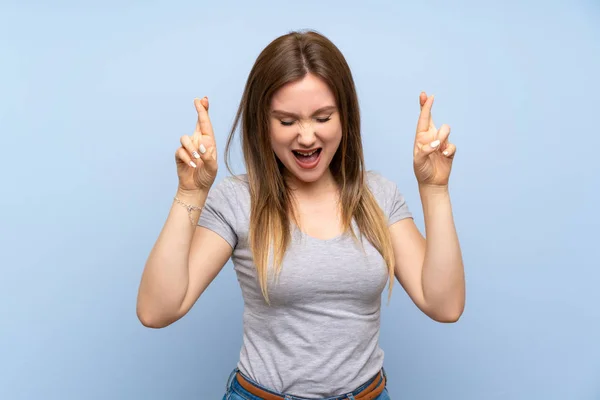 Adolescente Chica Sobre Aislada Pared Azul Con Los Dedos Cruzando — Foto de Stock