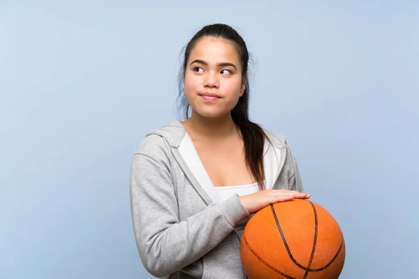 Молода Азіатська Дівчина Грає Баскетбол Над Ізольованим Фоном Роблячи Сумніви — стокове фото