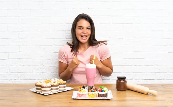 Junges Mädchen Mit Vielen Verschiedenen Mini Kuchen Feiert Einen Sieg — Stockfoto