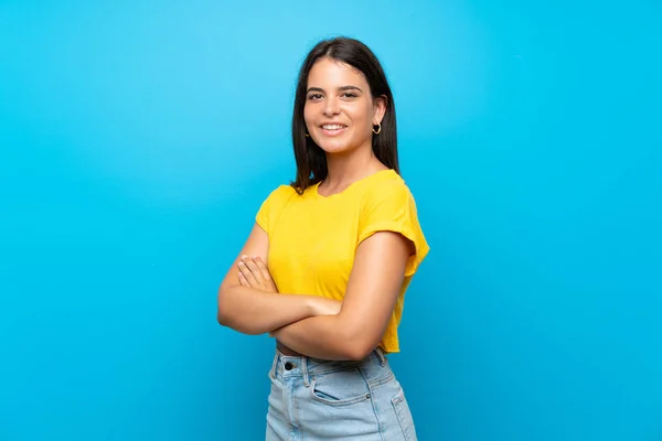 Jong Meisje Geïsoleerde Blauwe Achtergrond Met Armen Gekruist Vooruitkijkend — Stockfoto