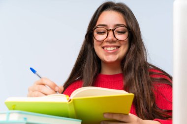 Bir masada okuyan mutlu genç öğrenci kız