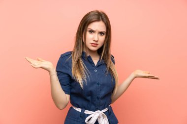 Izole pembe arka plan üzerinde Genç kız bir şey anlamak için mutsuz