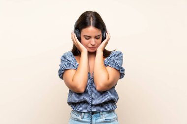 Izole arka plan üzerinde genç kız kulaklık ile müzik dinlerken