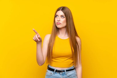 Şeffaf ekranda dokunarak izole sarı arka plan üzerinde genç kadın