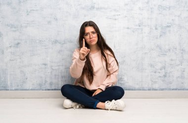 Genç öğrenci kız bir masada sinirli ve ön işaret okuyan